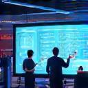 Employees using digital whiteboard in high-tech office